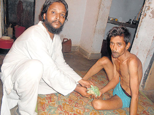A volunteer of Roti Bank serves food to a poor man in Mahoba in Uttar Pradesh.