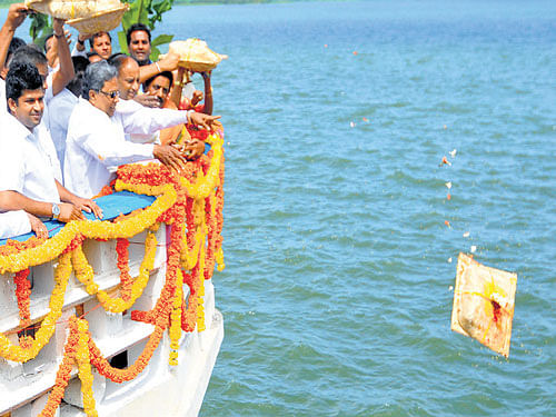 Chief Minister Siddaramaiah offers 'bagina' to Kabini reservoir at Beechanahalli in H D Kote taluk on&#8200;Sunday. Lok Sabha member Prathap Simha and others are also seen. (Right) The water level at the KRS stood at 104.15 feet on Sunday. The Full Reservoir Level of the reservoir is 124.80 feet. The inflow was  measured at 30,150 cusecs. DH PHOTOs