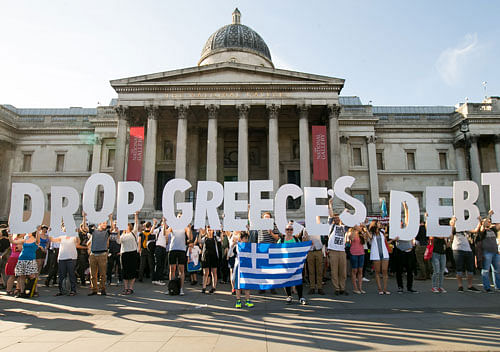 Demonstrators holding letters to form a banner take part in a protest against the European Central Bank, in Trafalgar Square, London, over Greece's debt repayments. AP photo