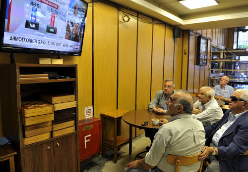 People look at the first opinion polls at a cafe in the northern city of Thessaloniki, Greece. Reuters