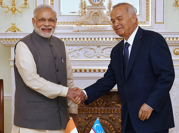 Prime Minister Narendra Modi shakes hands with Uzbekistan's President Islam Karimov during a meeting in Tashkent, Uzbekistan on Monday. PTI Photo