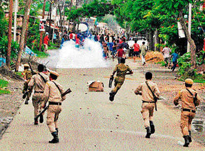 Police fire teargas shells to disperse the protesters at Khurai in Imphal East district on Thursday. PTI