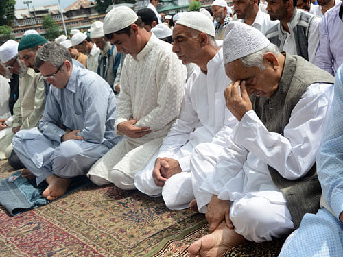 Chief Minister of Jammu and Kashmir Mufti Mohammad Sayeed and former Chief Minister Omar Abdullah with other people offering prayers on the occasion of Eid-ul-Fitr at Hazratbal shrine in Srinagar on Saturday. PTI Photo