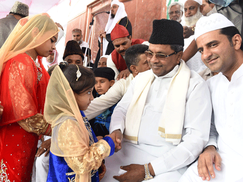 Chief minister Siddaramaiah greets young muslim girls on the occassion of Ramzan festival at Chamarajpet Idgah grounds in Bengaluru on Saturday. DH photo.