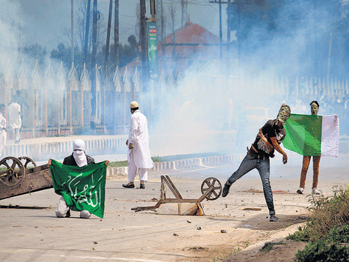 Protesters holds a Pakistani flag as they clash with paramilitary soldiers in Srinagar. AP