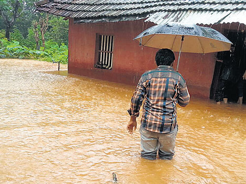 Knee-deep in water Water gushes into a house in Vittal of Puttur taluk, Dakshina Kannada district on Sunday.