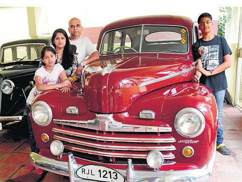 proud Naveen, wife Rekha, son Gaurav and daughter Vainavi standing next to 1947 Ford V8 Super Deluxe with the 1933 Austin 7 in the background.