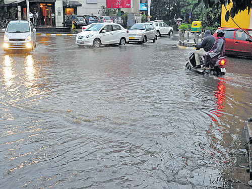 Motorists struggle tomanoeuvre through stagnant rainwater on Vittal Mallya Road as heavy rains lashed the City on Monday. DH PHOTO