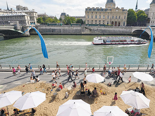 Tourists sunbathe on the Seine river banks on the third day of Paris Plages, a major cultural and touristic event in Paris. In France, tourism is used underwrite the protection and nurturing of the country's culture, landscape andway of life.