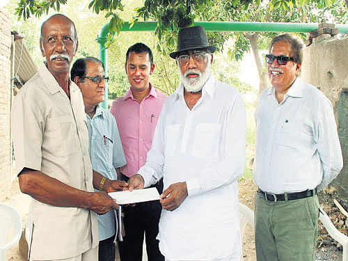 Raman Parmar receives a cheque for supplying solar power to the grid in Gujarat.