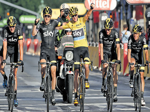 champion stuff: Britain's Chris Froome (centre, yellow jersey) of team Sky celebrates his victory with team-mates on&#8200;Sunday. reuters