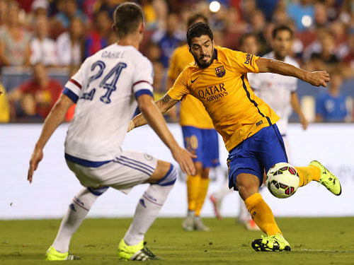 Barcelona forward Luis Suarez (right) attempts to shoot past Chelsea's Gary Cahill during their International Champions Cup match on Tuesday. AP
