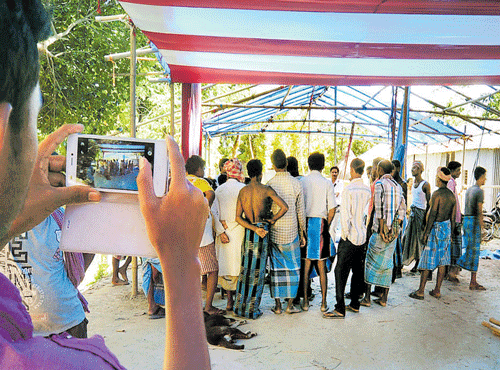Jainal Abedin, a resident of a Bangladeshi enclave in West Bengal, takes a photo of preparations for the formal exchange of enclaves between India and Bangladesh. DH PHOTO