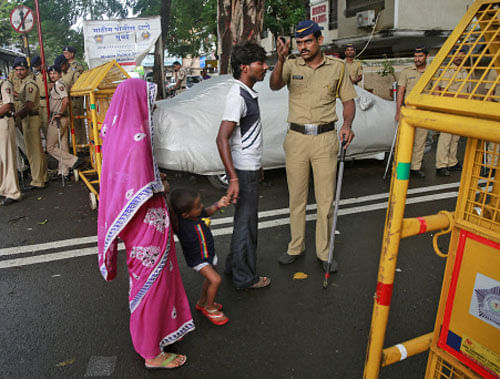 Police officer stops a family at a barricade in the neighborhood of Yakub Abdul Razak Memon's family residence in Mumbai. AP Photo