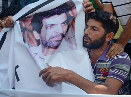 A supporter of Independent Member of Legislative Assembly (MLA) Sheikh Abdul Rashid embraces a photograph of 1993 Mumbai blast convict Yakub Memon during a protest against the his hanging. PTI photo