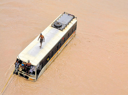 STRANDED A bus surrounded by flood waters of Sabarmati river at Panchasar village in Patan district of Gujarat. PTI