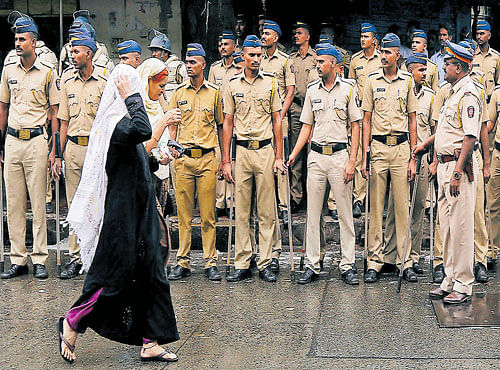 UNDERVIGILANCE: Women walk past policemen standing guard near the residence of Yakub Memon in Mumbai on Thursday. REUTERS