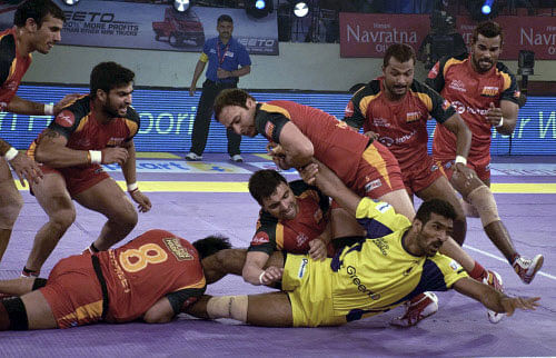 Players in action during a Pro Kabaddi League match between Telugu Titans (Yellow) and Bengaluru Bulls (Red) at Patliputra Sports Complex in Patna. PTI