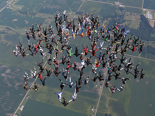 In this photo provided by Gustavo Cabana, members of an international team of skydivers join hands, flying head-down to build their world record skydiving formation. AP Photo