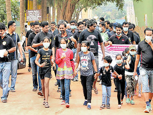 The residents of areas around Thubarahalli, near Marathahalli, take out a march against bad roads in their locality on Saturday. DH PHOTO