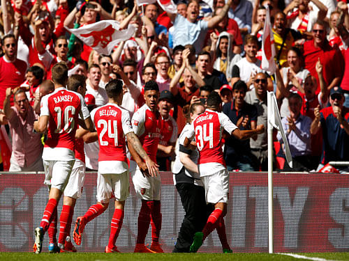 Alex Oxlade Chamberlain (C) celebrates with team mates after scoring the first goal for Arsenal. Reuters Photo.