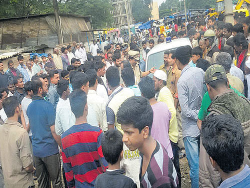 Brutal: People and police gather at the spot where Abdullah (inset) was murdered at HAL in the City on Sunday.   DH&#8200;PHOTO