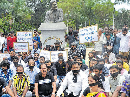 Members of Kannada Film Directors' Association, Dr Rajkumar Fans' Association and artistes hold a silent protest at Raj Samadhi on the premises of Kanteerava Studios in the City on Sunday. DH PHOTO