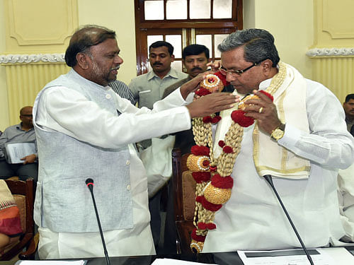 Chief Minister Siddaramaiah being felicitated by Social Welfare Minister H Anjaneya during the high level meeting on Former CM Late. Devraj Uras centenary celebrations at Conference Hall, Vidhan Soudha in Bengaluru. DH Photo