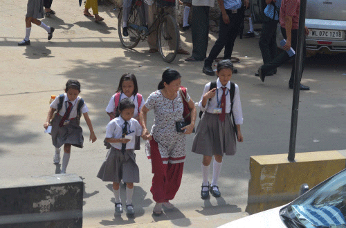 A Naga woman crosses a street with her children in Dimapur, Nagaland on Tuesday. PTI Photo