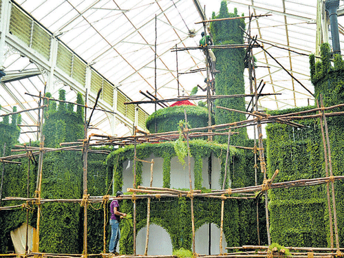 Workers build a replica of the Bangalore Palace ahead of the annual flower show at Lalbagh in Bengaluru on Wednesday. DH photo