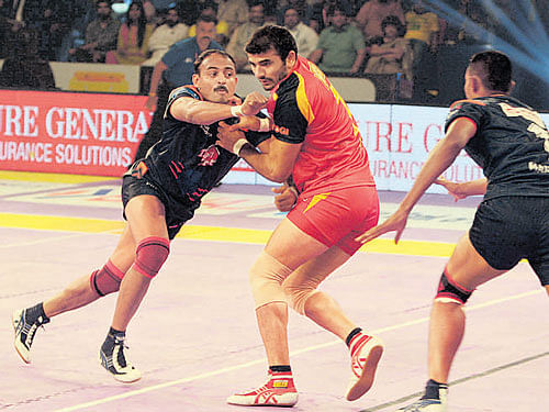 Bengaluru Bulls' Ajay Thakur (centre) tries to dodge Warriors' defence on Thursday.