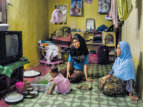 all for survival: Ambiya Khatu, centre, who married a man who paid for her release from smugglers in Thailand, watches her niece at her home in Kuala Lumpur. While some Rohingya women agree to such marriages to escape imprisonment, others are tricked or coerced. nyt