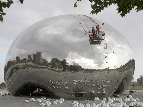 Workers polish a new sculpture in the shape of a giant oil bubble at a tourism resort built near the first drilling well of the Karamay oil field in Xinjiang Uighur Autonomous Region. Reuters Photo