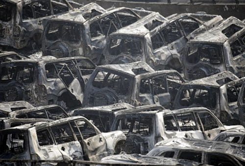 Damaged vehicles are seen near the site of the explosions at the Binhai new district, Tianjin, August 13, 2015. Two massive explosions caused by flammable goods ripped through an industrial area in the northeast Chinese port city of Tianjin late on Wednesday. Reuters