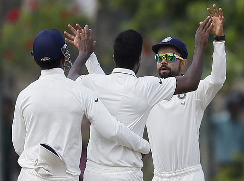 India's captain Kohli celebrates with his teammate Aaron after the dismissal of Sri Lanka's Prasad during the third day of their first test cricket match in Galle. Reuters