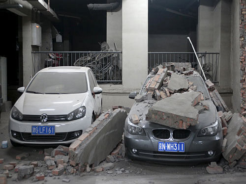 Damaged cars and broken wall are pictured inside the parking lot of a building where residents were evacuated, at Binhai new district in Tianjin. Reuters Photo