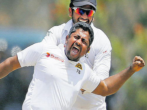 Wrecker-in-chief: Sri Lanka's Rangana Herath (front) celebrates with his teammate Dimuth Karunaratne after taking the wicket of India's Ajinkya Rahane on the fourth day  of their first Test match in Galle on Saturday. REUTERS
