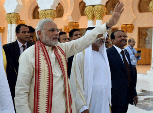 Prime Minister Narendra Modi waves to people at the Sheikh Zayed Grand Mosque on the first day of his two-day visit to the UAE, in Abu Dhabi, United Arab Emirates on Sunday. PTI