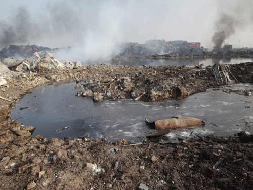 A pool of unknown liquid is seen as smoke rises from damaged shipping containers at the site of Wednesday night's explosions in the Binhai new district of Tianjin. Minute traces of cyanide have been detected in waters near the Tianjin port, the State Oceanic Administration (SOA) said acknowledging that it was spreading into the waters of the port which is on the western shore of the Bohai Bay. Reuters photo