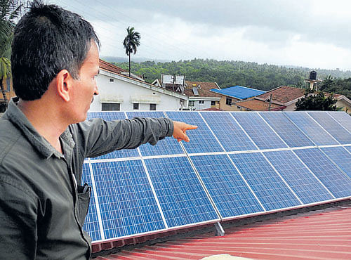 INDEPENDENT Shrikant Hegde with the Solar Rooftop Photovoltaic Panel Unit at his house in Sirsi. PHOTO BY AUTHOR