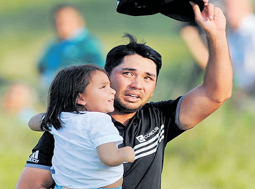 RED-LETTER DAY: Jason Day walks off the 18th green with his son Dash after winning the PGA Championship tournament at Whistling Straits, Wisconsin on Sunday. Day finished with a record total of 20-under to win his first major. REUTERS