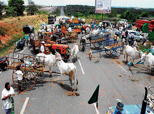 Farmers block the Tarihalla bypass road that connects to the Pune-Bengaluru national  highway, with bullock-carts and tractors on Monday. DH PHOTO