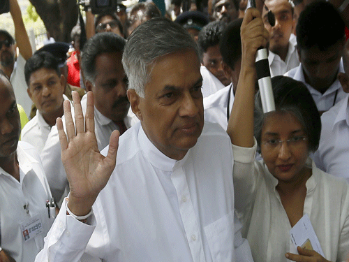Sri Lanka's Prime Minister Ranil Wickremesinghe (C) waves as he arrives with his wife Maithree Wickramasinghe at a polling station. Reuters