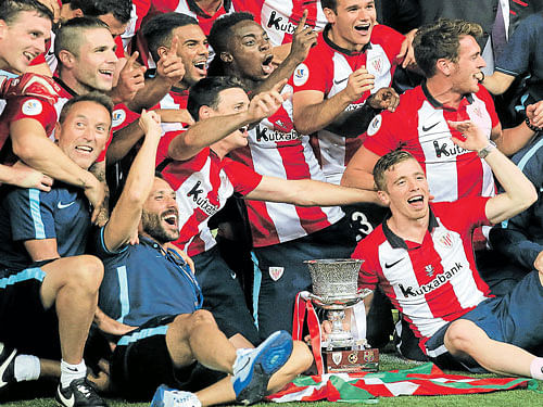 Champions: Athletic Bilbao's players pose with the Spanish Super Cup after their win over Barcelona at Camp Nou. reuters