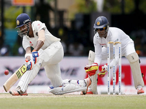 India's Lokesh Rahul (L) plays a shot next to Sri Lanka's wicketkeeper Dinesh Chandimal during the first day of their second test cricket match in Colombo, August 20, 2015. Reuters Photo.