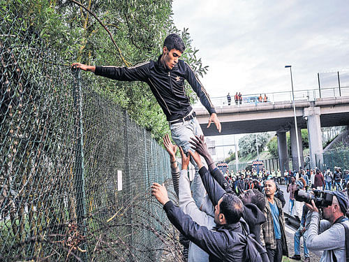 Having made it through an initial police blockade, a large group of migrants come up against another police line outside of the Eurotunnel in Calais, France. The desperate scene playing out everyday is just one chapter in a painful drama panning across Europe. NYT