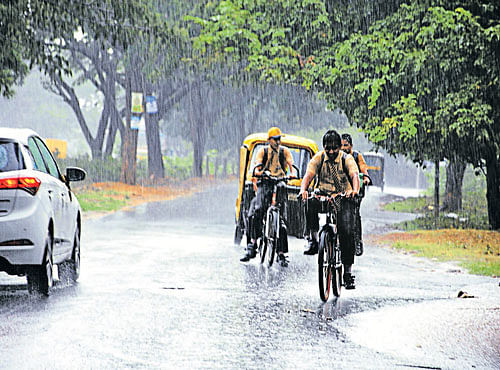 SEARCH FOR COVER: School children rush home as heavy rain lashes Hubballi city on Friday evening. DH PHOTO