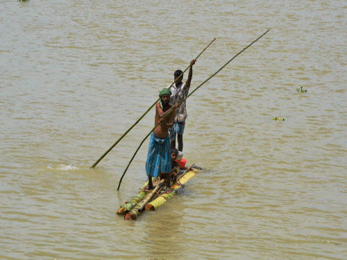 Villagers commute on a banana-raft in a flooded village in Morigaon district of Assam. PTI photo