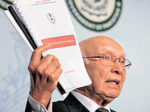 Pakistan's National Security Adviser Sartaj Aziz shows dossiers about Indian intelligence agency RAW's involvement in promoting terrorism in Pakistan at a press conference in Islamabad on Saturday. PTI