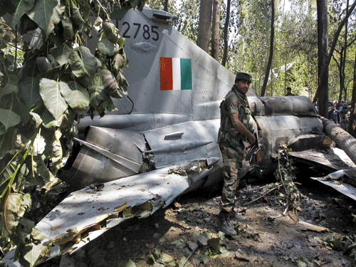 Indian army soldier stands in front of the wreckage of a MiG-21 Bison aircraft of IAF after it crashed in Soibugh. Reuters File Photo
